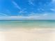 A serene beach scene with clear turquoise water gently lapping the shore under a bright blue sky at 880 Mandalay Ave # C512, Clearwater Beach, FL 33767