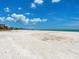 Wide sandy beach under a bright blue sky with scattered clouds, offering a peaceful retreat by the sea at 880 Mandalay Ave # C512, Clearwater Beach, FL 33767