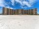 Large beachfront condo complex with multiple stories and rows of balconies offering stunning views of the ocean at 880 Mandalay Ave # C512, Clearwater Beach, FL 33767