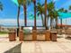 Outdoor community grilling area featuring stainless steel grills, counter space, and nearby seating with trash cans nearby at 880 Mandalay Ave # C512, Clearwater Beach, FL 33767