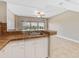 Kitchenette view with sink, white cabinets and a view of the balcony and neighborhood at 880 Mandalay Ave # C512, Clearwater Beach, FL 33767