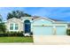 Charming single-Gathering home with a well-manicured lawn, stone accents, and a vibrant blue door at 10702 Laxer Cay Loop, San Antonio, FL 33576
