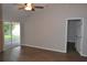 Spacious living room with wood-look floors, access to the screened-in porch, and ceiling fan at 11227 Thicket Ct, Tampa, FL 33624
