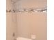 Close up of tub and shower featuring tiled surround, and updated fixtures at 11227 Thicket Ct, Tampa, FL 33624