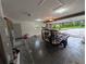 Wide angle view of the open garage with a trailer and door to the exterior at 11308 Echo View Dr, Odessa, FL 33556