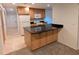 Open kitchen includes sleek granite counters, wood cabinets, white appliances, and tile flooring at 11308 Echo View Dr, Odessa, FL 33556