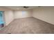 Spacious carpeted living area with large windows and a ceiling fan at 11308 Echo View Dr, Odessa, FL 33556