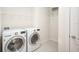 Well-lit laundry room with washer and dryer, along with practical shelving for storage at 11745 Brighton Knoll Loop, Riverview, FL 33579