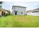 Large grassy backyard with a sliding glass door, privacy fence, and well-maintained lawn at 11926 Grand Kempston Dr, Gibsonton, FL 33534