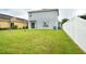 Spacious backyard with lush green grass, a privacy fence, and a view of the home's exterior at 11926 Grand Kempston Dr, Gibsonton, FL 33534
