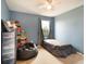 Bedroom with a window, ceiling fan, and blue walls at 11926 Grand Kempston Dr, Gibsonton, FL 33534