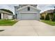 Home with a two-car garage and driveway surrounded by green grass and rock gardens at 11926 Grand Kempston Dr, Gibsonton, FL 33534