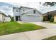 Charming two-story home with a gray roof, attached garage and green front lawn at 11926 Grand Kempston Dr, Gibsonton, FL 33534