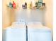 Functional laundry room with appliances and ample shelving for storage and cleaning supplies at 11926 Grand Kempston Dr, Gibsonton, FL 33534