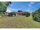 Expansive backyard featuring lush grass, a screened-in patio, and a wooden fence for privacy at 1216 Fox Chapel Dr, Lutz, FL 33549
