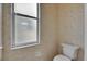 Small bathroom with white toilet and frosted window providing privacy at 1216 Fox Chapel Dr, Lutz, FL 33549