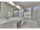 Bright bathroom with dual sinks, bathtub and glass-enclosed shower at 1216 Fox Chapel Dr, Lutz, FL 33549