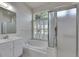 Bright bathroom with a garden tub under a large window and glass enclosed shower at 1216 Fox Chapel Dr, Lutz, FL 33549