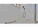 White tiled shower featuring an adjustable shower head and a convenient grab bar at 1216 Fox Chapel Dr, Lutz, FL 33549