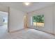 Bright bedroom with a neutral palette, a window with a view, and a doorway to another room at 1216 Fox Chapel Dr, Lutz, FL 33549