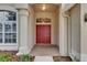 Elegant front entrance with a red double door, brick flooring, and decorative pillars at 1216 Fox Chapel Dr, Lutz, FL 33549