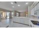 Bright kitchen with white cabinets and appliances flowing to the home's patio, providing an open space at 1216 Fox Chapel Dr, Lutz, FL 33549