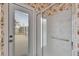 Bathroom shower and exterior door with floral wallpaper, tiled shower with grab bar and a clear glass door at 1216 Fox Chapel Dr, Lutz, FL 33549