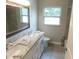 Bright bathroom features a dual sink vanity with granite countertop and a large framed mirror at 12417 N Rome Ave, Tampa, FL 33612
