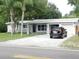Well-kept single-story house with an attached two-car garage, palm trees, and a car in the driveway at 12417 N Rome Ave, Tampa, FL 33612