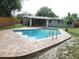 Backyard swimming pool surrounded by lush landscaping and a well-maintained patio area at 12417 N Rome Ave, Tampa, FL 33612