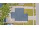 Birds-eye-view of the house featuring a large roof, gravel yard, white fence, and a long driveway at 13916 Briardale Ln, Tampa, FL 33618