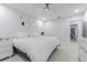 A comfortable main bedroom boasts white walls and flooring, a ceiling fan and a decorative arrangement of mirrors at 13916 Briardale Ln, Tampa, FL 33618