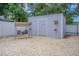 A well-maintained outdoor shed sits on a gravel base, alongside a relaxing porch swing at 13916 Briardale Ln, Tampa, FL 33618
