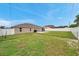 Spacious backyard with a well-maintained lawn, a wooden privacy fence, and a cozy patio area at 15442 Arvin Dr, Brooksville, FL 34604