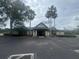A view of the exterior of the community clubhouse with palm trees and ample parking at 15442 Arvin Dr, Brooksville, FL 34604
