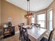 Cozy dining room featuring a table, wooden chairs, a modern light fixture, and bright windows at 15442 Arvin Dr, Brooksville, FL 34604