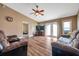 Comfortable living room with hardwood floors, ceiling fan, and access to the backyard through French doors at 15442 Arvin Dr, Brooksville, FL 34604