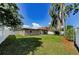 Spacious backyard featuring green grass, mature trees, and a privacy fence, ideal for relaxation at 1800 Mapleleaf Blvd, Oldsmar, FL 34677