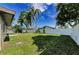 Home boasting a spacious, green backyard enclosed by a white fence, offering privacy at 1800 Mapleleaf Blvd, Oldsmar, FL 34677