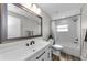 Bright bathroom featuring a large mirror, white vanity, and a shower with white tiling at 1800 Mapleleaf Blvd, Oldsmar, FL 34677