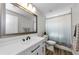 Bright bathroom featuring a large mirror, white vanity, and a shower with stylish curtain at 1800 Mapleleaf Blvd, Oldsmar, FL 34677