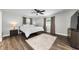 Bright bedroom with hardwood floors, ceiling fan, and two large windows at 1800 Mapleleaf Blvd, Oldsmar, FL 34677