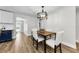 Bright dining area includes modern chandelier, wood floors, and access to the kitchen and backyard at 1800 Mapleleaf Blvd, Oldsmar, FL 34677