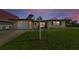 Charming single-story home with manicured lawn, inviting entrance, and attached garage under a twilight sky at 1800 Mapleleaf Blvd, Oldsmar, FL 34677