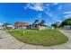 Single-story home with well-kept lawn, mature trees, and a street sign for wayfinding in this friendly neighborhood at 1800 Mapleleaf Blvd, Oldsmar, FL 34677