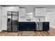 Modern kitchen boasts stainless steel appliances, white quartz countertops, and stylish blue cabinetry at 1800 Mapleleaf Blvd, Oldsmar, FL 34677