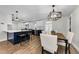 Kitchen and dining area showcasing wood floors, modern light fixtures, and stylish island with seating at 1800 Mapleleaf Blvd, Oldsmar, FL 34677