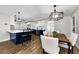 Open-concept kitchen with an island, stainless steel appliances, and dining area with contemporary lighting at 1800 Mapleleaf Blvd, Oldsmar, FL 34677