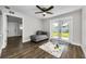 Open living area with wood flooring, a ceiling fan, and a door leading to the backyard at 1800 Mapleleaf Blvd, Oldsmar, FL 34677