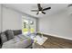 Bright living room with a ceiling fan, a grey chaise lounge, and view of backyard at 1800 Mapleleaf Blvd, Oldsmar, FL 34677